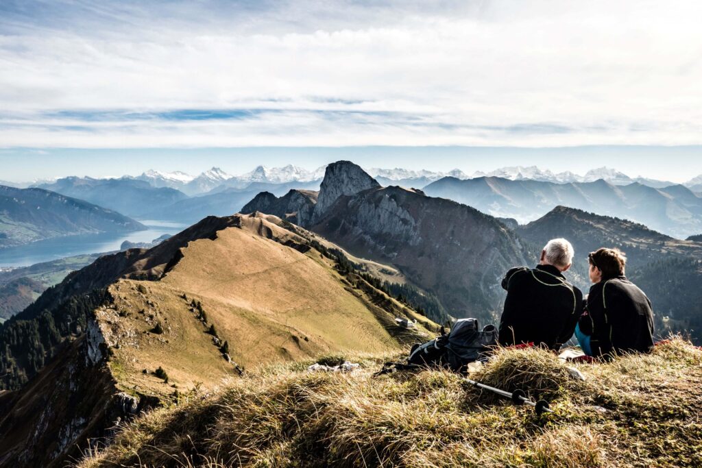 Paar sitzt auf einem Berggipfel